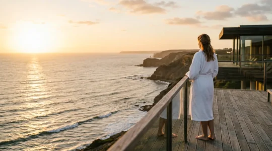 Personne en peignoir contemplant l'océan Atlantique depuis la terrasse d'un centre de thalasso au coucher du soleil